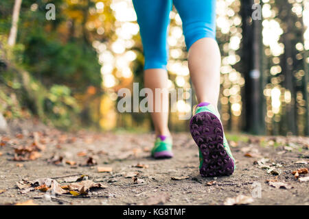 Balades et randonnées en femme forêt d'automne, les chaussures de sport. Le jogging, la randonnée ou la formation à l'extérieur à l'automne la nature. Concept de santé et de remise en forme d'inspiration. Banque D'Images