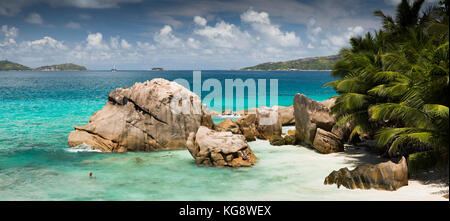 Les Seychelles, La Digue, Anse Patates, touristiques en mer à l'abri derrière d'énormes rochers de granit Banque D'Images