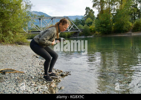 Caucasian woman est titulaire d'un saumon dans la rivière Squamish en Colombie-Britannique Banque D'Images