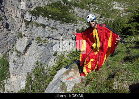 BASE Wingsuit cavalier est de penser à sa prochaine étape à sauter de la falaise derrière lui. La concentration est élevée pour l'étape suivante pour lancer vers le bas. Banque D'Images