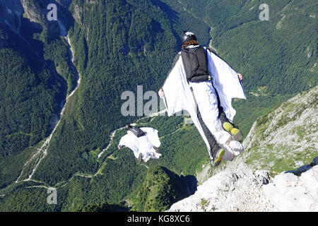 Ces cavaliers sont BASE cratie ensemble de lancement d'une falaise dans la vallée profonde. L'intérieur de leurs Wingsuits ils volent le long de la montagne. Banque D'Images