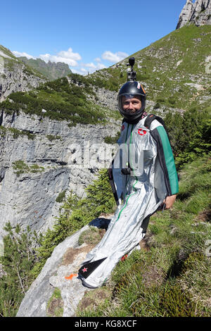 BASE Wingsuit cavalier est de penser à sa prochaine étape à sauter de la falaise derrière lui. La concentration est élevée pour l'étape suivante pour lancer vers le bas. Banque D'Images