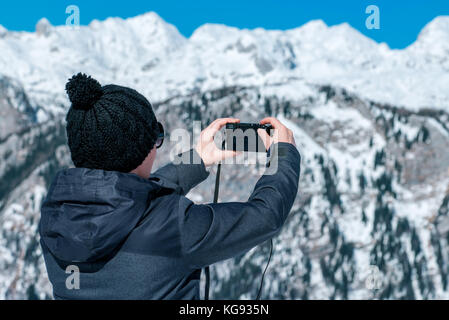 Woman photo panoramique prise de beaux paysages de montagne d'hiver avec l'appareil photo numérique compact Banque D'Images