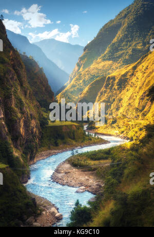 Un paysage extraordinaire avec des montagnes de l'himalaya, belle rivière en courbe, vert forêt, ciel bleu avec des nuages et soleil jaune en automne au Népal. m Banque D'Images