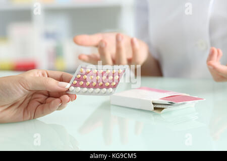 Close up of a Girl mains acheter pilules contraceptives et pharmacien expliquant dans une pharmacie