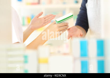 Près d'un pharmacien mains Vente de médicament à un client dans un intérieur de la pharmacie Banque D'Images