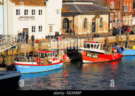 Weymouth, Dorset. 5th novembre 2017 - les gens se enveloppent de chaleur et de profiter d'un après-midi ensoleillé d'automne dans le vieux port historique de Weymouth crédit: stuart fretwell/Alamy Live News Banque D'Images
