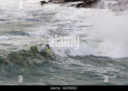 Un jeune surfeur qui fait une vague dans une mer agitée, Port Gaverne, Port Isaac, Cornwall, Royaume-Uni, 5th novembre 2017. Banque D'Images