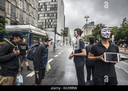 Sao Paulo, Brésil. 5 novembre 2017. Des activistes de l'organisation Anonymous for the Voiceless se tiennent près de l'avenue Paulista alors qu'ils portent des masques et tiennent des écrans affichant des vidéos des industries de la viande, des œufs et de la fourrure, le 5 novembre 2017. Le groupe soutient un style de vie végétalien et proteste contre la maltraitance des animaux dans les industries mentionnées. Crédit : cris Faga/ZUMA Wire/Alamy Live News Banque D'Images