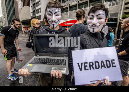 Sao Paulo, Brésil. 5Th nov, 2017. Des militants de l'organisation pour les sans-voix anonyme, se tiennent près de l'avenue Paulista comme ils portent des masques et maintenez-écrans pour afficher des vidéos à partir de la viande, des œufs et des industries, le 5 novembre 2017. Le groupe prend en charge un style de vie vegan, et les protestations contre la violence envers les animaux dans les secteurs d'activités susmentionnés. crédit : cris faga/zuma/Alamy fil live news Banque D'Images