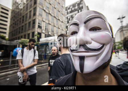 Sao Paulo, Brésil. 5Th nov, 2017. Des militants de l'organisation pour les sans-voix anonyme, se tiennent près de l'avenue Paulista comme ils portent des masques et maintenez-écrans pour afficher des vidéos à partir de la viande, des œufs et des industries, le 5 novembre 2017. Le groupe prend en charge un style de vie vegan, et les protestations contre la violence envers les animaux dans les secteurs d'activités susmentionnés. crédit : cris faga/zuma/Alamy fil live news Banque D'Images