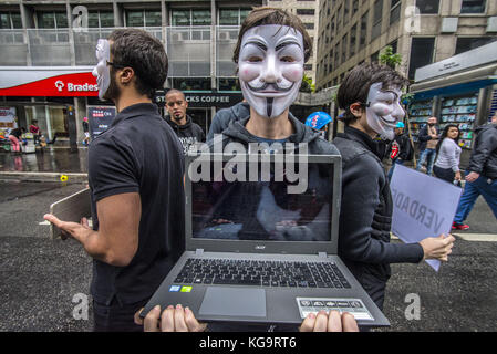 Sao Paulo, Brésil. 5 novembre 2017. Des activistes de l'organisation Anonymous for the Voiceless se tiennent près de l'avenue Paulista alors qu'ils portent des masques et tiennent des écrans affichant des vidéos des industries de la viande, des œufs et de la fourrure, le 5 novembre 2017. Le groupe soutient un style de vie végétalien et proteste contre la maltraitance des animaux dans les industries mentionnées. Crédit : cris Faga/ZUMA Wire/Alamy Live News Banque D'Images