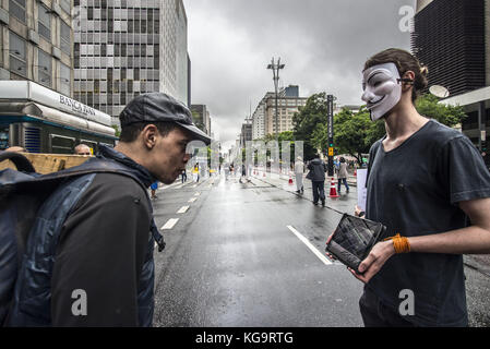 Sao Paulo, Brésil. 5 novembre 2017. Des activistes de l'organisation Anonymous for the Voiceless se tiennent près de l'avenue Paulista alors qu'ils portent des masques et tiennent des écrans affichant des vidéos des industries de la viande, des œufs et de la fourrure, le 5 novembre 2017. Le groupe soutient un style de vie végétalien et proteste contre la maltraitance des animaux dans les industries mentionnées. Crédit : cris Faga/ZUMA Wire/Alamy Live News Banque D'Images