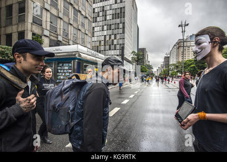 Sao Paulo, Brésil. 5Th nov, 2017. Des militants de l'organisation pour les sans-voix anonyme, se tiennent près de l'avenue Paulista comme ils portent des masques et maintenez-écrans pour afficher des vidéos à partir de la viande, des œufs et des industries, le 5 novembre 2017. Le groupe prend en charge un style de vie vegan, et les protestations contre la violence envers les animaux dans les secteurs d'activités susmentionnés. crédit : cris faga/zuma/Alamy fil live news Banque D'Images