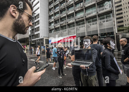 Sao Paulo, Brésil. 5 novembre 2017. Des activistes de l'organisation Anonymous for the Voiceless se tiennent près de l'avenue Paulista alors qu'ils portent des masques et tiennent des écrans affichant des vidéos des industries de la viande, des œufs et de la fourrure, le 5 novembre 2017. Le groupe soutient un style de vie végétalien et proteste contre la maltraitance des animaux dans les industries mentionnées. Crédit : cris Faga/ZUMA Wire/Alamy Live News Banque D'Images