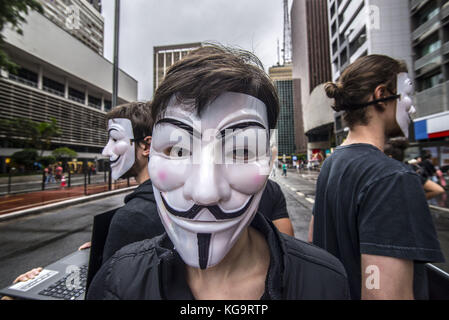 Sao Paulo, Brésil. 5 novembre 2017. Des activistes de l'organisation Anonymous for the Voiceless se tiennent près de l'avenue Paulista alors qu'ils portent des masques et tiennent des écrans affichant des vidéos des industries de la viande, des œufs et de la fourrure, le 5 novembre 2017. Le groupe soutient un style de vie végétalien et proteste contre la maltraitance des animaux dans les industries mentionnées. Crédit : cris Faga/ZUMA Wire/Alamy Live News Banque D'Images