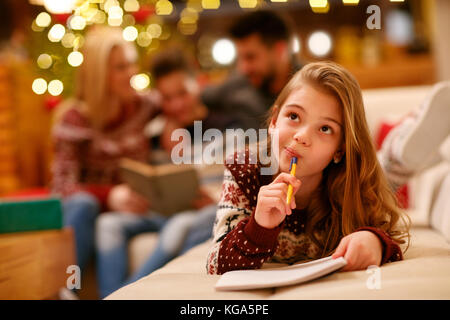 Cute little girl écrit une lettre au Père Noël pour Noël Banque D'Images