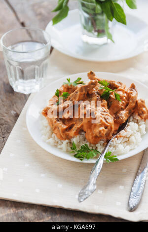 Lave riz au bœuf stroganoff sur une plaque blanche. Banque D'Images