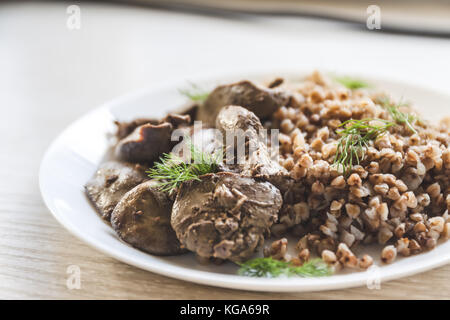 Foie de poulet compote et gruau de sarrasin sur une nappe blanche, en rétro tonifiant. Banque D'Images