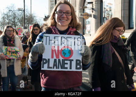 Un jeune activiste souriant tenant une pancarte "il n'y a pas de plante B" avec une image de la planète Terre, comme commentaire sur le réchauffement climatique / les questions environnementales Banque D'Images
