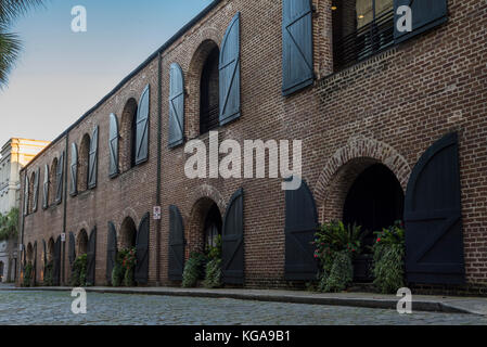 Un magnifique bâtiment de briques historique de Charleston avec portes en bois décoratif sous un ciel de coucher du soleil Banque D'Images