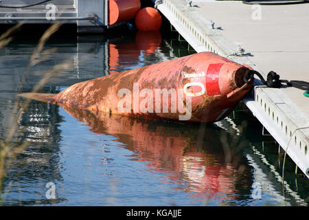 Bouée quai numéro 10 reflétant dans l'eau dans une marina à cape cod. Banque D'Images