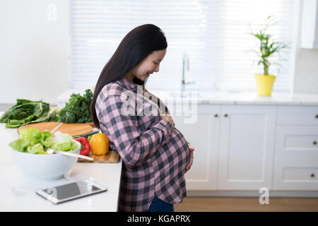 Smiling Beautiful woman in kitchen Banque D'Images