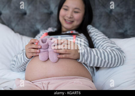 Pregnant woman looking at chaussettes dans chambre Banque D'Images