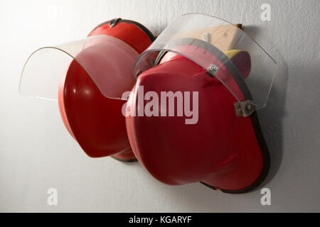 Close-up of hard hats hanging on hook Banque D'Images