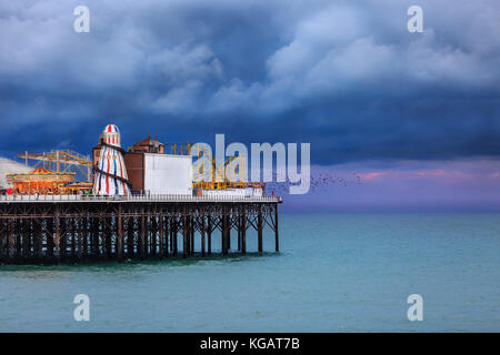 Brighton Pier Victorian Pleasure Pier Funfair contre le ciel sombre et spectaculaire de la mer Banque D'Images