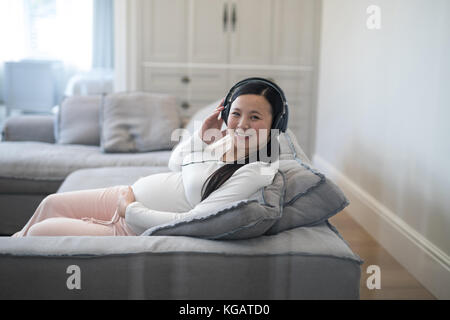 Portrait de femme enceinte à l'écoute de la musique sur le casque Banque D'Images