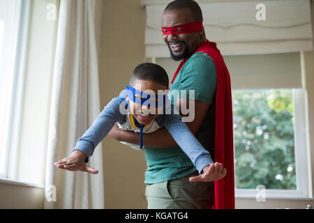 Smiling fils et le père se faisant passer pour un super héros à la maison Banque D'Images