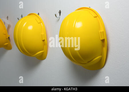 Close-up of hard hats hanging on hook Banque D'Images