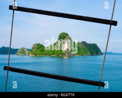 Formations karstiques de la baie de Ha Long à travers un voile échelle de corde, Vietnam Banque D'Images