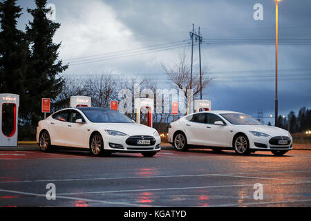 PAIMIO, FINLANDE - le 14 novembre 2015 : Tesla Model S blanc deux voitures sont facturés à Tesla Supercharger station à nuit. Tesla suralimenter statio Banque D'Images