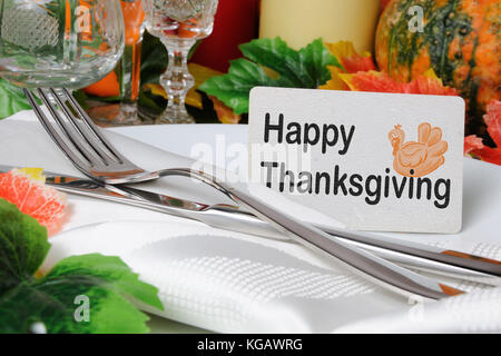 Carte Happy Thanksgiving sur une assiette avec une serviette et couverts sur la table Banque D'Images