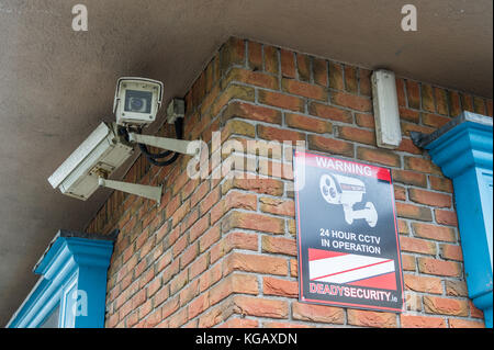 Deux caméras de surveillance sur un mur de brique dans le sens opposé. Banque D'Images