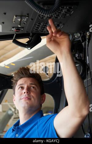 Homme aero ingénieur travaillant dans le cockpit de l'hélicoptère Banque D'Images