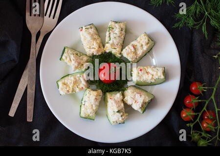 Apéritif à partir d'un concombre frais à la viande de crabe, oeuf, fromage et aneth. noël et nouvel an concept Banque D'Images