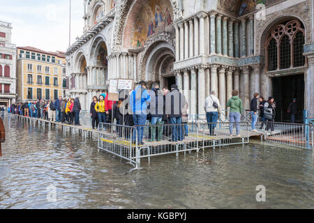 Venise, Vénétie, Italie. 6Th Nov 2017. Acqua Alta marée haute à partir de la lagune provoquant des inondations temporaires sur la Piazza San Marco. Passerelle, ou des passerelles, sont installés à la circulation des piétons avec queung les touristes d'entrer dans la Basilique de San Marco. Credit : Mary Clarke/Alamy Live News Banque D'Images