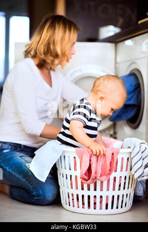 Jeune maman avec un petit garçon à faire des travaux ménagers. Banque D'Images