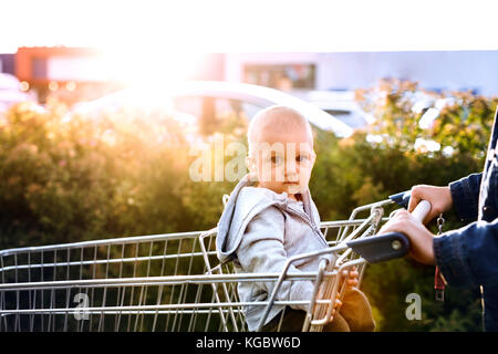 Mother with baby boy faire du shopping dans le parking. Banque D'Images