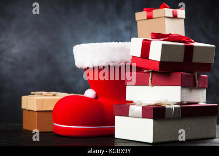 Santa's shoe avec coffrets cadeaux sur fond sombre Banque D'Images
