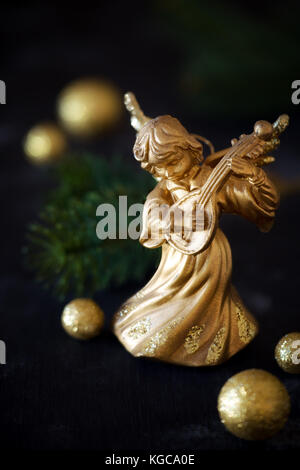 Ange de Noël jouant de la mandoline avec des décorations d'or Banque D'Images