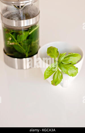 Thé de menthe poivrée et de basilic sur le brassage tableau blanc Banque D'Images