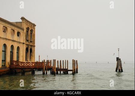 Un bâtiment délabré mais historique waterfront sur l'île de Murano de Venise, Italie, par une froide journée d'automne. Banque D'Images