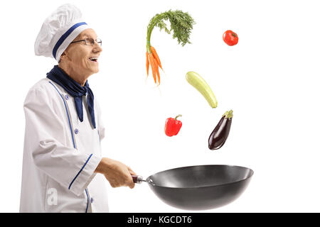 Personnes âgées chef de cuire les légumes dans un wok pan isolé sur fond blanc Banque D'Images