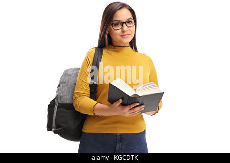 Teenage student femelle avec un sac à dos et un livre regardant la caméra isolé sur fond blanc Banque D'Images