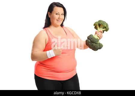 L'excès de femme tenant une haltère de brocoli et de pointage isolé sur fond blanc Banque D'Images