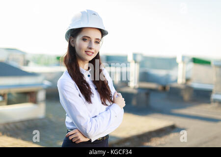 Businesslady attrayant en chemisier blanc, jupe noire et casque sur le toit Banque D'Images